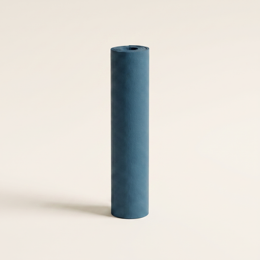 TrueSelf yoga mat in slate blue, rolled and standing upright